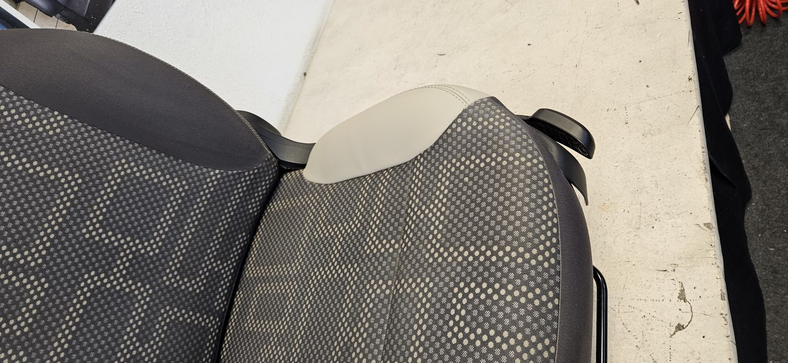 Detail eines neu bezogenen Sitzes in Leder und gelochtem Stoff