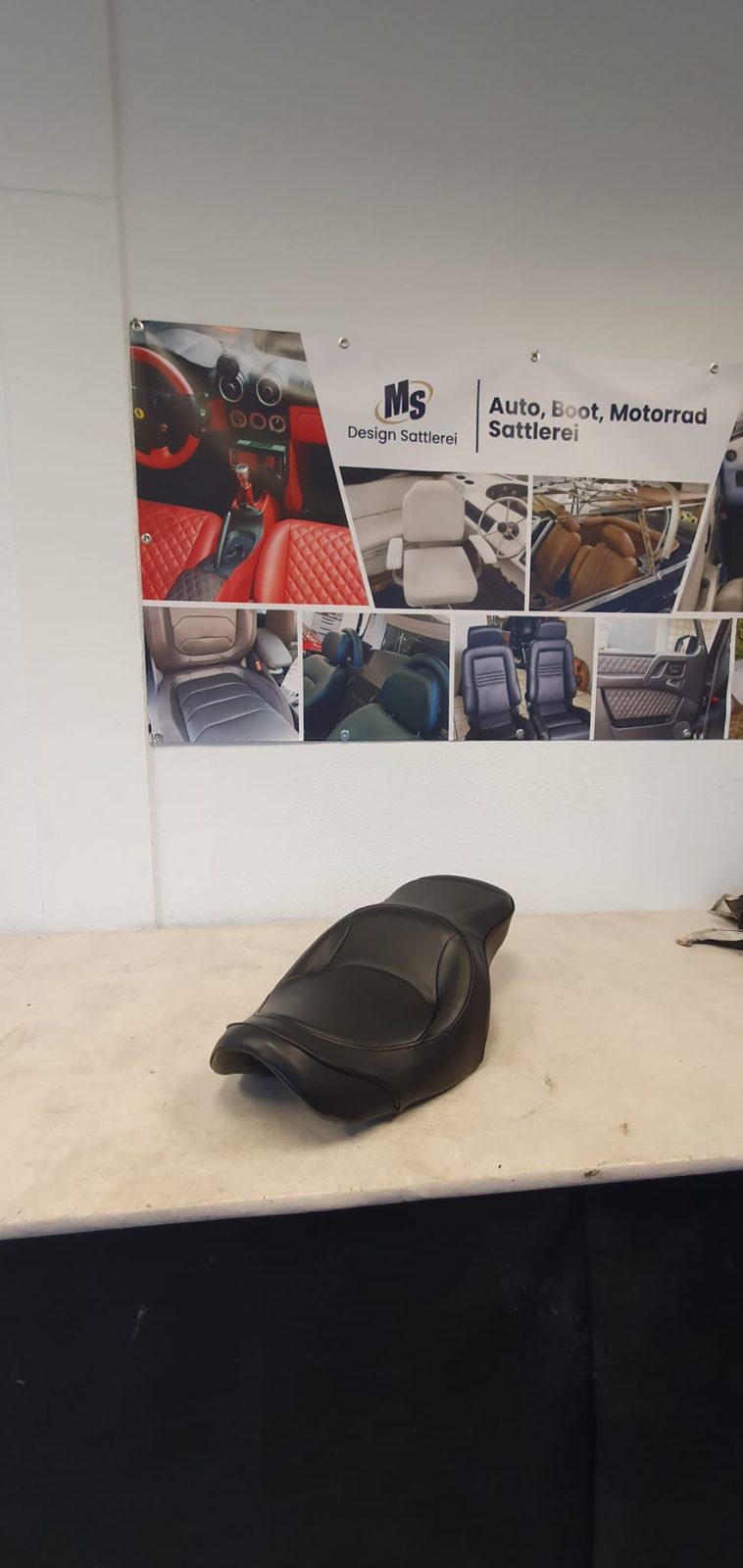 Neu bezogene Motorradsitzbank auf dem Werktisch